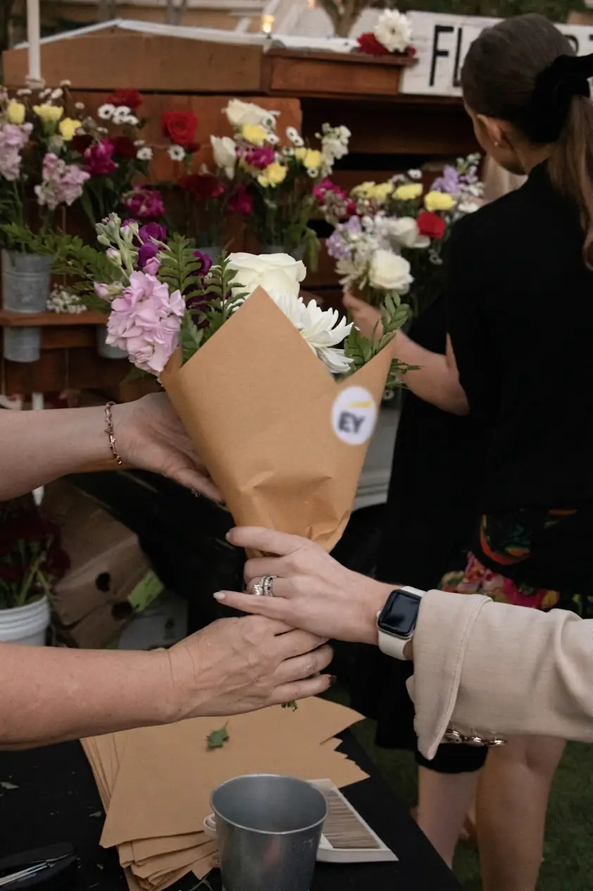 Custom-wrapped bouquet handed to a guest at a corporate reception, Orlando