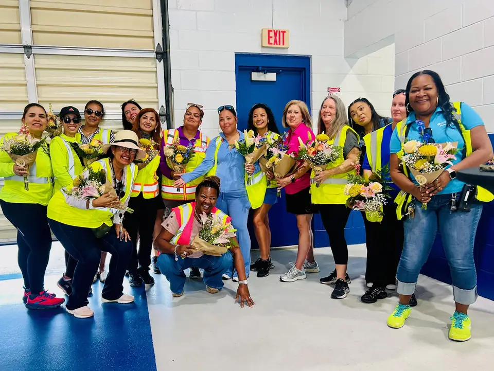 Employees celebrating with fresh bouquets at a workplace appreciation event